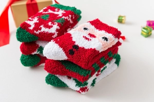 Detailed texture of thick Christmas coral fleece socks with Santa and snowflake patterns