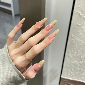 Faux ongles amande style français avec pointes jaunes et motifs de fleurs roses