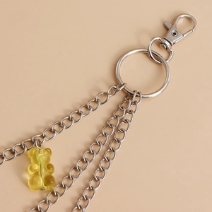 Detail of silver multi-layer chain with a cute yellow gummy bear resin charm