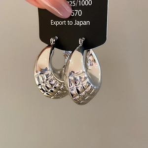 Detail view of silver S925 geometric hoop earrings with textured woven design