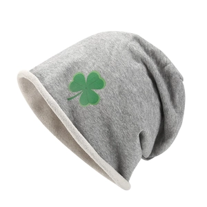 Détail macro du bonnet en maille grise avec motif trèfle vert et texture extensible