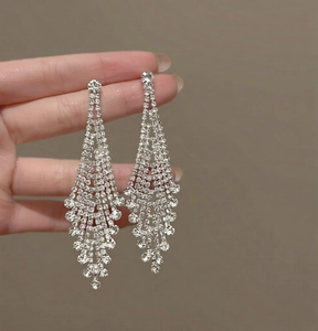 Detail shot of elegant long silver tassel earrings with sparkling rhinestone crystals