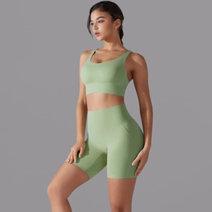 Dettaglio dei pantaloncini sportivi a vita alta verde salvia e reggiseno coordinato