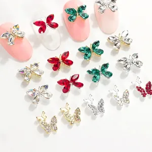 Vista macro de dijes para uñas de mariposa de cristal K9 con pedrería y base dorada