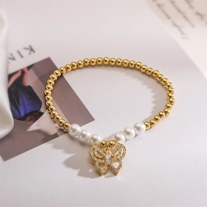 Detailed close-up of gold beads and white pearls with a zircon butterfly pendant charm
