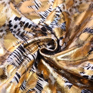 Detailed macro view of metallic gold leopard print and geometric stripes on luxury fabric
