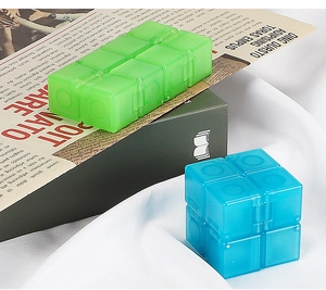 Detailed view of blue and green translucent fidget cubes on newspaper background