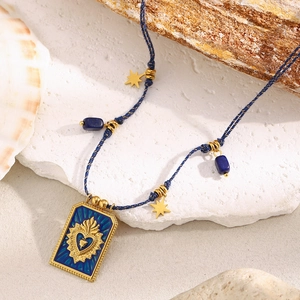 Detail of 18K gold plated square pendant with blue enamel heart on woven rope chain