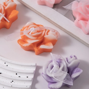 Macro detail of rose shaped scented candles in various colors on a decorative tray