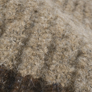 Gros plan d'un bonnet en laine bicolore marron montrant la texture chaude et épaisse