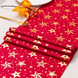 Close-up of red velvet holiday table runner with gold foil stars and snowflakes