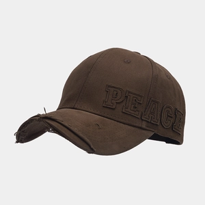 Detail of distressed brim and 3D PEACE embroidery on dark brown cotton canvas baseball cap