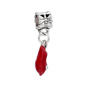 Close-up of silver bead with bow texture and red enamel high heel pendant with crystals