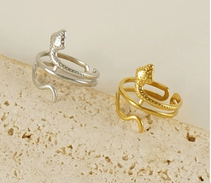 Macro detail of snake-shaped rings with scale texture on natural white stone base