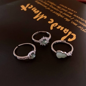 Detailed macro shot of three silver adjustable rings with green stones and white zircons