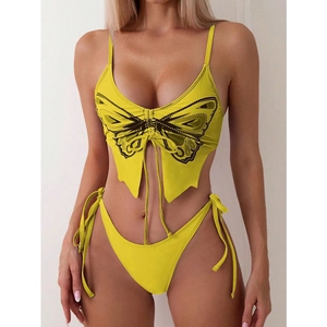 Detailed view of yellow butterfly-shaped bikini top with black embroidery and tie strings