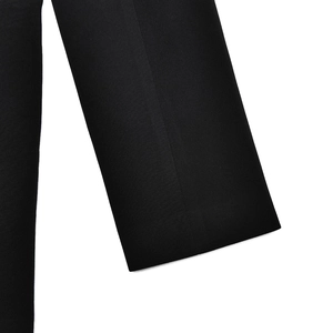 Close-up of the black woven blazer sleeve detail showing texture and fine stitching