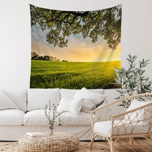 Détail d'une tapisserie murale de paysage avec un arbre au coucher du soleil sur un sofa