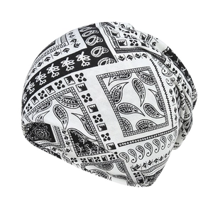 Detail of slouchy beanie featuring black and white paisley and geometric stripe patterns