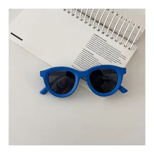 Detailed top view of bright blue round silicone children's sunglasses with dark grey lenses