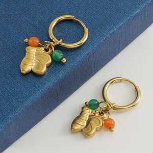 Détail de boucles d'oreilles en acier titane or 18 carats avec breloques abeilles