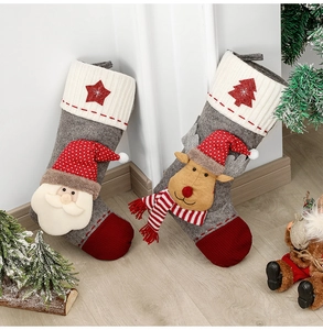 Détail de chaussettes de Noël en feutre avec Père Noël et renne en 3D sur un parquet