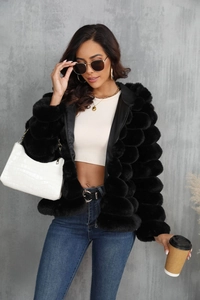 Detail of black faux fur jacket with bubble texture on a fashion model in a city setting
