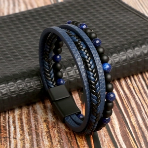 Détail macro du bracelet en cuir pour homme avec cordons tressés, perles et fermoir aimanté