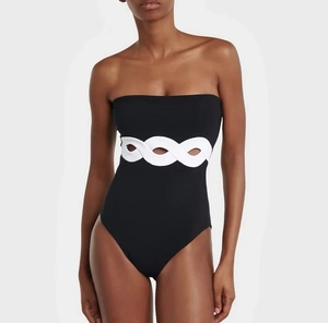 Detail of black strapless swimsuit with white cut-out waist bands and slim fit design