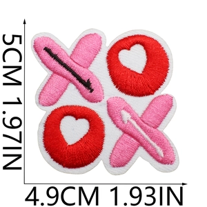 Detailed macro view of XOXO embroidered heart patch with size markings in centimeters
