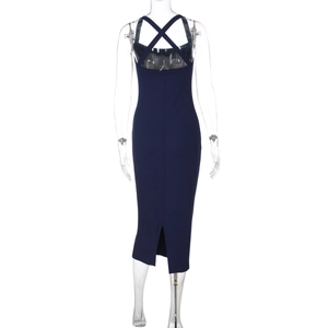 Detail of navy knit dress featuring cross back straps and a slit on a ribbed slim fit