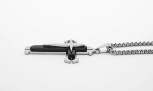 Detail of silver box chain and dual-tone cross pendant with black metal inlay