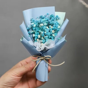 Detailed view of mini blue and white dried baby's breath bouquet with matte paper wrap