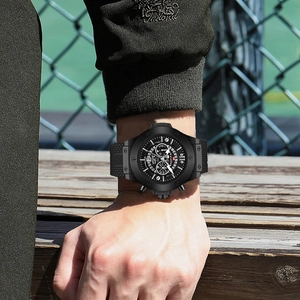 Sporty black chronograph watch with skeleton dial and silicone strap on a male wrist