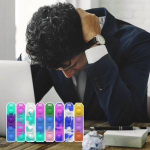 Stress-relieving rainbow pop fidget keychain set displayed in an office workspace setting