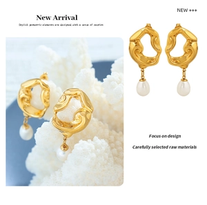 Detail view of gold lava texture earrings with elegant white teardrop pearl pendant