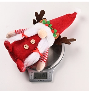 Rudolph faceless gnome Christmas doll with antlers being weighed on a digital scale