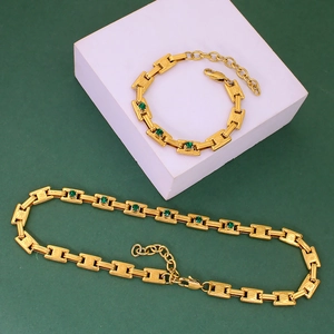 Detailed macro view of 18K gold plated chain with green gemstone inlay necklace and bracelet