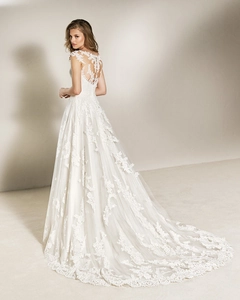 Detail of elegant lace wedding dress featuring a sheer back design and long bridal train