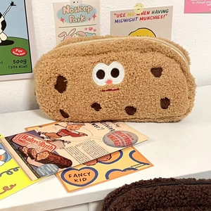 Cute brown plush cookie pencil case with cartoon eyes in a vintage retro setting