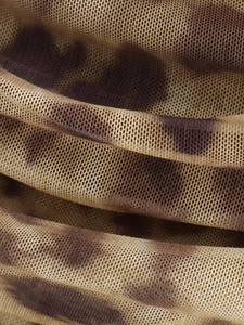 Macro view of leopard print mesh fabric detail with breathable translucent texture