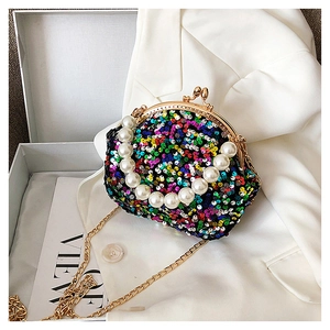Close-up of colorful sequin shell bag with large pearl handle and golden chain strap