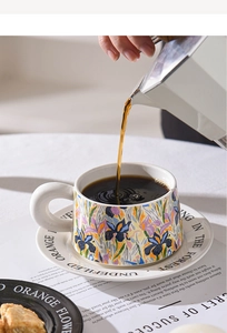 Pouring coffee into a ceramic cup with floral patterns and a matching saucer