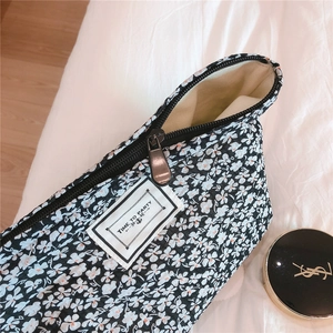 Detail of floral makeup bag with TIME TO PARTY label and silver zipper closure
