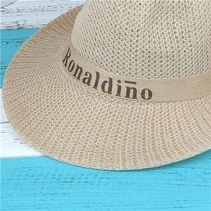 Detailed texture of woven straw sun hat featuring a decorative Ronaldinho ribbon band