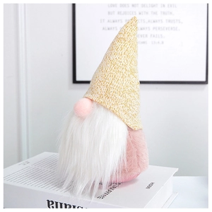 Close-up of pink velvet gnome plush with white faux fur beard and yellow knitted hat