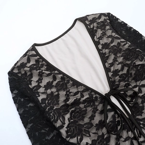 Detailed view of sheer black floral lace fabric with plunging V-neck and delicate ties