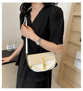 Detail of color-block box handbag featuring metal clasp and chain strap on a female model