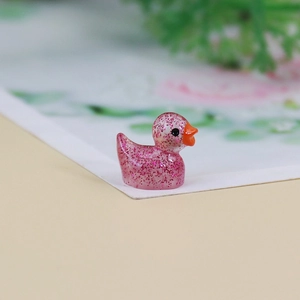 Macro shot of a mini pink resin duck with glitter and a glossy finish for DIY micro landscapes