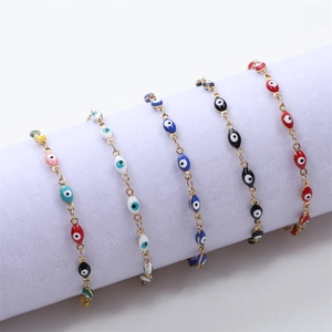 Five assorted 18K gold-plated Evil Eye enamel bracelets on a white display stand